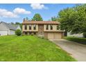 Beautiful home featuring brick and siding, an attached two-car garage, and a well-manicured lawn at 5847 Democracy Dr, Indianapolis, IN 46254