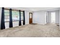 Bright living room boasting abundant natural light, neutral carpet, and a beautiful front door at 6616 S Cross St, Pendleton, IN 46064