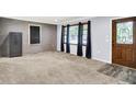 Cozy living room with modern gray walls, gray carpet, an ornate door, and abundant natural light at 6616 S Cross St, Pendleton, IN 46064