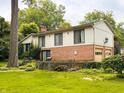 Spacious backyard featuring a lovely lawn, mature trees, and beautiful stone details around the property at 7038 E 65Th St, Indianapolis, IN 46256