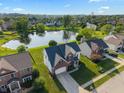 Aerial view of a neighborhood featuring a two-story home near a pond with a fountain at 7356 Woodington Pl, Indianapolis, IN 46259