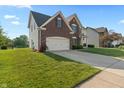 A charming home with a well-kept lawn, featuring brick accents and an attached two-car garage at 7356 Woodington Pl, Indianapolis, IN 46259