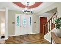 Welcoming foyer with stylish lighting, decorative door with glass details, hardwood flooring, and adjacent staircase at 7720 Langwood Dr, Indianapolis, IN 46268