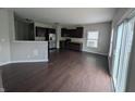 Modern kitchen with dark cabinets, stainless steel appliances, hardwood flooring, and sliding glass doors at 8415 Fieldfare Way, Indianapolis, IN 46237