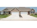 Two-unit home with brick facade, white garage doors, well-maintained lawns, and concrete driveways at 8842 Twain Ln, Indianapolis, IN 46239