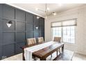 Stylish dining room featuring a modern light fixture, gray paneled wall, and patterned wallpaper at 9740 Logan Ln, Fishers, IN 46037