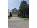 Traditional brick home with a well-maintained lawn and mature shade tree in front at 10523 Dark Star Dr, Indianapolis, IN 46234