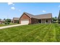 Lovely single-story home with a brick facade, well-maintained lawn, and a paved driveway at 10938 E Mount Vernon N Trl, Indianapolis, IN 46229