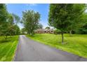View of the home from a long driveway and the tree lined front yard at 12196 N Beth Ann Dr, Camby, IN 46113