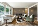Sunlit living area featuring stylish furniture, modern fireplace, and wood-look flooring at 130 N High School Rd, Indianapolis, IN 46214