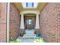 Welcoming brick front porch, decorated with colorful flower pots at 1457 Birdsong Dr, Westfield, IN 46074