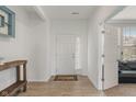 Bright foyer featuring a white door, wood flooring, and a view into the living room at 15736 Conductors Dr, Westfield, IN 46074