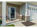 View of front door with two ornate chairs and brick accents at 15736 Conductors Dr, Westfield, IN 46074