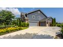 A three car garage, with a large, well-manicured driveway, and colorful landscape at 16310 Nightshore Ln, Fishers, IN 46037