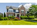 Charming two-story brick home with a well-manicured lawn and lush landscaping at 16310 Nightshore Ln, Fishers, IN 46037