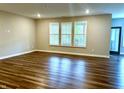 Bright living room features wood floors and multiple windows with lovely views at 17324 Americana Xing, Noblesville, IN 46060