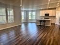 Open-concept living room and kitchen area with wood floors, modern cabinets, island, and lots of natural light at 17324 Americana Xing, Noblesville, IN 46060