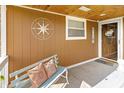 Inviting front porch with a cozy bench, decorative pillows, and nautical themed compass rose at 227 Vestal Rd, Plainfield, IN 46168