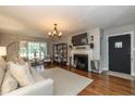 Cozy living room with a fireplace, a large window, and hardwood floors at 253 W Westfield Blvd, Indianapolis, IN 46208