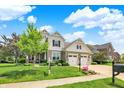 Inviting home with a three-car garage, lush lawn, and colorful flower beds enhancing the curb appeal at 2715 Benmore Ct, Zionsville, IN 46077