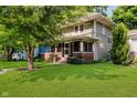 Beautiful home with a well-maintained lawn, mature trees, and a welcoming screened-in porch entrance at 3246 N New Jersey St, Indianapolis, IN 46205