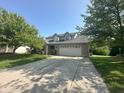 Charming two-story home with a well-maintained lawn, mature trees, and long driveway leading to a two-car garage at 3350 Shore Dr, Greenwood, IN 46143