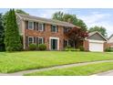 Charming brick home featuring a two-car garage and a well-maintained front yard with mature trees at 3439 Eden Park Dr, Carmel, IN 46033