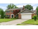 Charming brick home featuring a two-car garage and a well-maintained front yard with mature trees at 3439 Eden Park Dr, Carmel, IN 46033