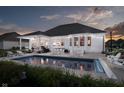 Inviting in-ground pool and outdoor entertaining space with string lights at dusk at 3821 Shady Lake Dr, Westfield, IN 46074