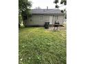 The backyard features a well-maintained lawn, exterior door and a grill at 4744 E 33Rd St, Indianapolis, IN 46218