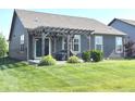The backyard features a pergola-covered patio, a grill, and lush green lawn at 5103 Covington Ave, McCordsville, IN 46055