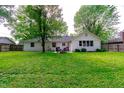 Spacious backyard featuring lush green grass and a charming patio seating area at 535 Radburn Dr, Indianapolis, IN 46214