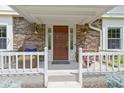 Inviting front porch with brick facade, elegant front door with sidelights, and charming decor at 59 Sycamore Dr, Carmel, IN 46033