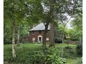 Exterior of beautiful brick home with mature trees and manicured lawn at 6125 N Olney St, Indianapolis, IN 46220