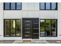 View of a modern style front door framed by sidelight windows, white siding, black trim, and gray concrete steps at 6164 Afton Crest, Indianapolis, IN 46220