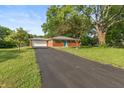 A one-story brick house with an attached two-car garage and a long black driveway at 7139 Buick Dr, Indianapolis, IN 46214