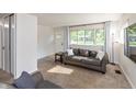 Bright living room features neutral carpet, large window with curtains, and comfortable couches at 7139 Buick Dr, Indianapolis, IN 46214