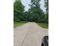 Long driveway leading to a home surrounded by mature trees and green lawns at 721 Maplewood Ave, Anderson, IN 46012