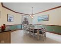 Dining room showcasing a decorative chandelier, carpet, wainscotting and a large table set for six at 7612 Freedom Woods Dr, Indianapolis, IN 46259