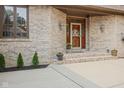 Close-up of the front entrance, showcasing brickwork, decorative door with glass and flowerpots at 7612 Freedom Woods Dr, Indianapolis, IN 46259