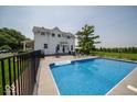 A beautiful backyard oasis with a sparkling in-ground swimming pool and ample seating area at 7728 W 200 S, New Palestine, IN 46163