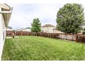 Large backyard with a well-maintained lawn, a wood fence for privacy, and mature trees to provide shade at 8116 Harshaw Dr, Indianapolis, IN 46239
