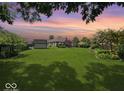 Expansive backyard featuring a lush green lawn, mature trees, and storage shed at 8144 Grassy Meadow Cir, Indianapolis, IN 46259