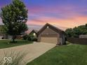 Single-Gathering brick home featuring an attached garage and landscaped front yard at 8144 Grassy Meadow Cir, Indianapolis, IN 46259