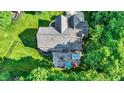Aerial view of a home with an expansive backyard, patio area, hot tub, and lush surrounding trees at 8261 Twin Pointe Cir, Indianapolis, IN 46236