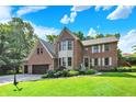 Beautiful two-story brick home featuring an attached garage and well-manicured lawn at 8261 Twin Pointe Cir, Indianapolis, IN 46236