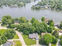A high aerial view of the home surrounded by mature trees near a lake in a residential neighborhood at 8429 Catamaran Dr, Indianapolis, IN 46236