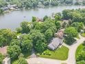 An aerial view of the home nestled among mature trees, close to a lake and surrounding neighborhood at 8429 Catamaran Dr, Indianapolis, IN 46236