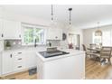 Bright kitchen featuring an island with cooktop, white cabinets, stainless steel appliances, and modern pendant lighting at 8429 Catamaran Dr, Indianapolis, IN 46236