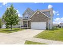 Attractive two-story home with brick and siding, a well-maintained lawn, and an attached two-car garage, exuding suburban charm at 8720 N Deer Crossing Blvd, McCordsville, IN 46055